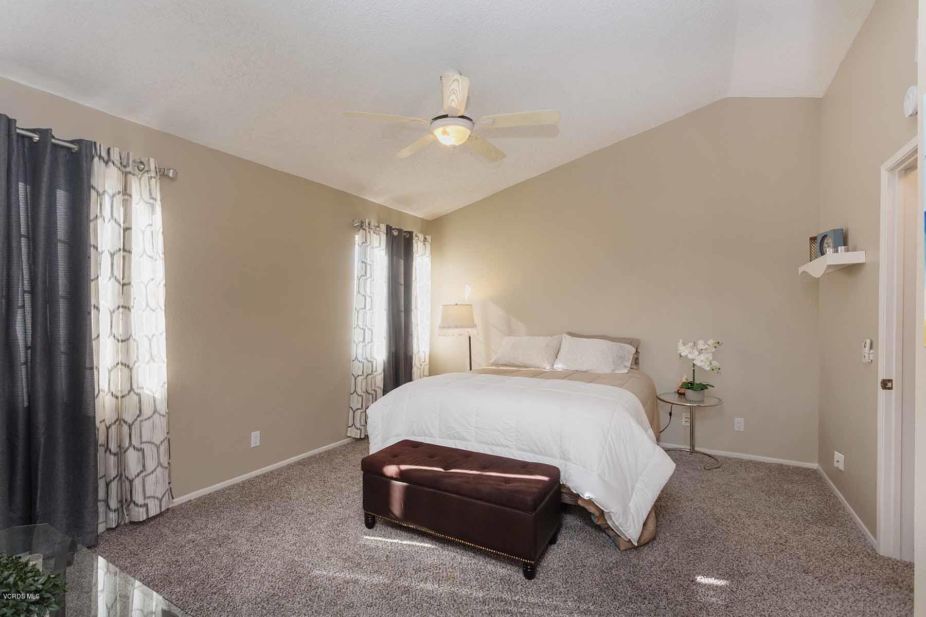 3902 Cochran Street, Unit 4 Simi Valley, CA 93063 - Photo 16 of 26 a bedroom with a bed and a chandelier