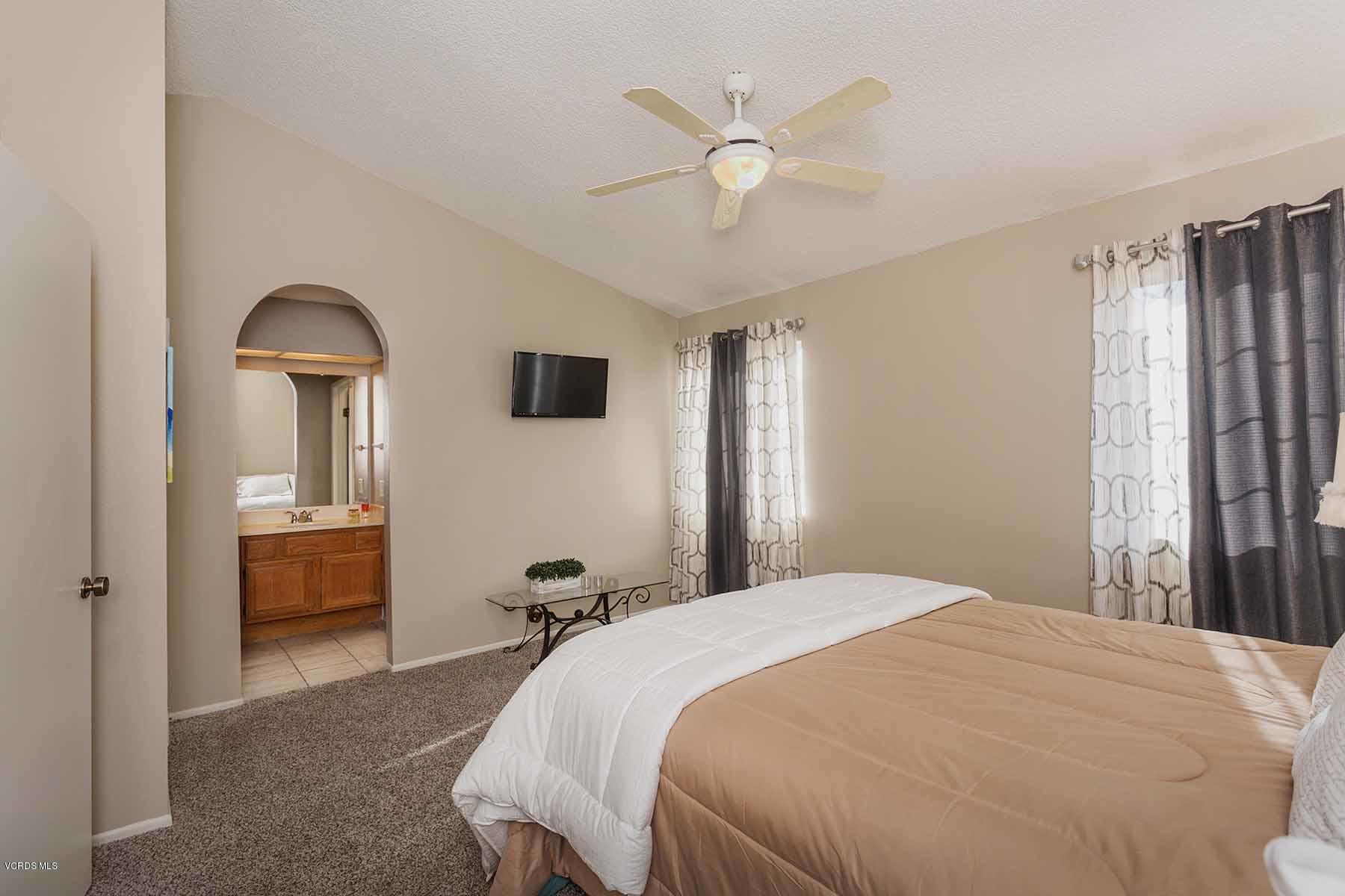 3902 Cochran Street, Unit 4 Simi Valley, CA 93063 - Photo 17 of 26 a bedroom with a bed and a chandelier