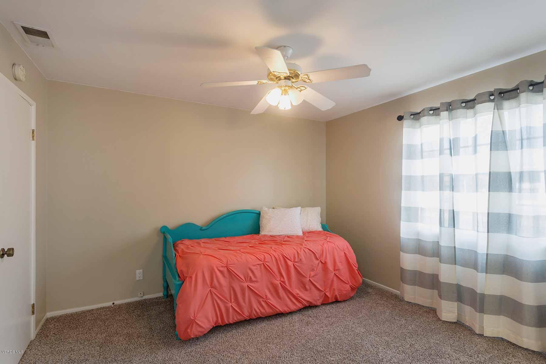 3902 Cochran Street, Unit 4 Simi Valley, CA 93063 - Photo 20 of 26 a bedroom with a bed and a chandelier