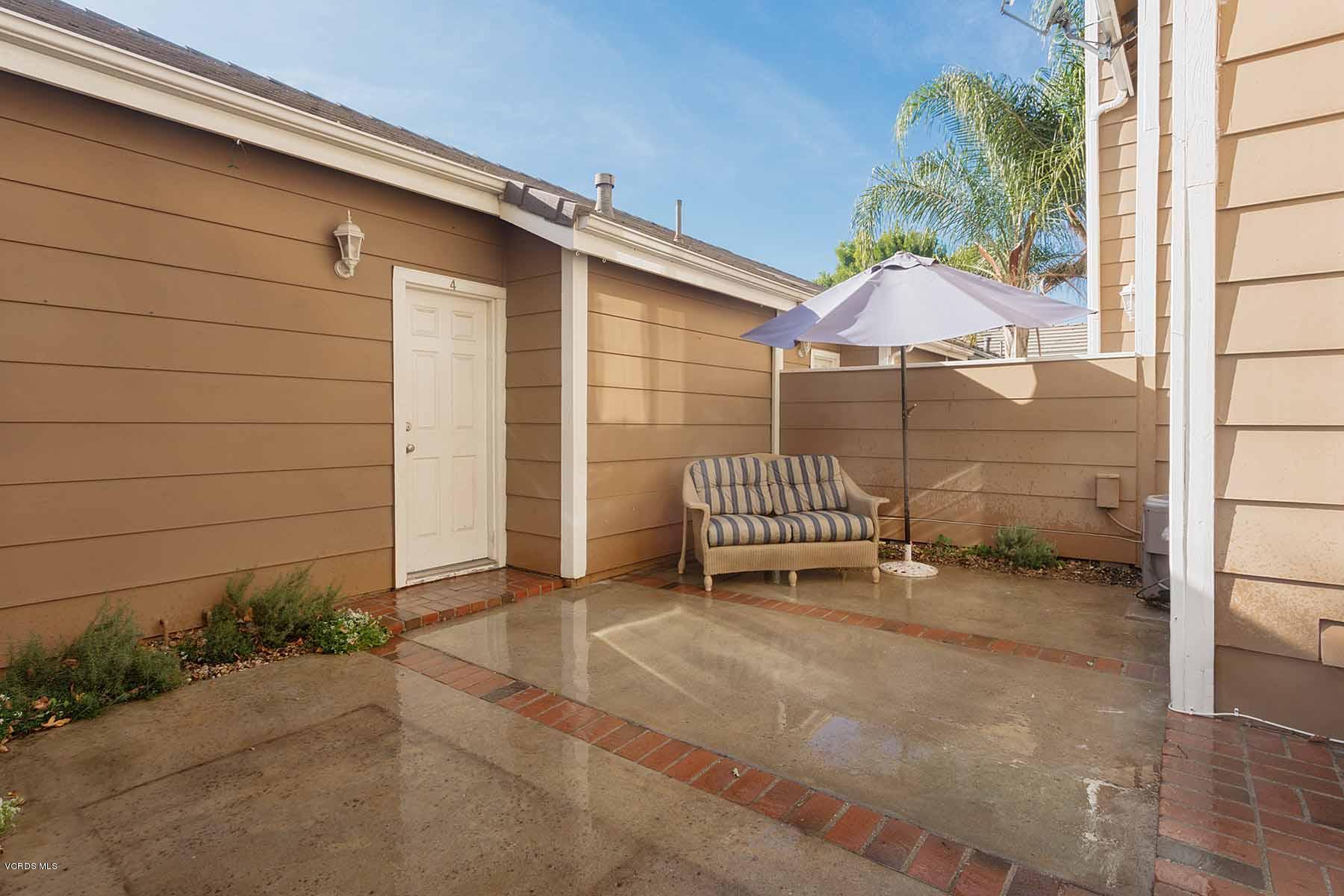 3902 Cochran Street, Unit 4 Simi Valley, CA 93063 - Photo 22 of 26 a backyard of a house with potted plants and brick wall