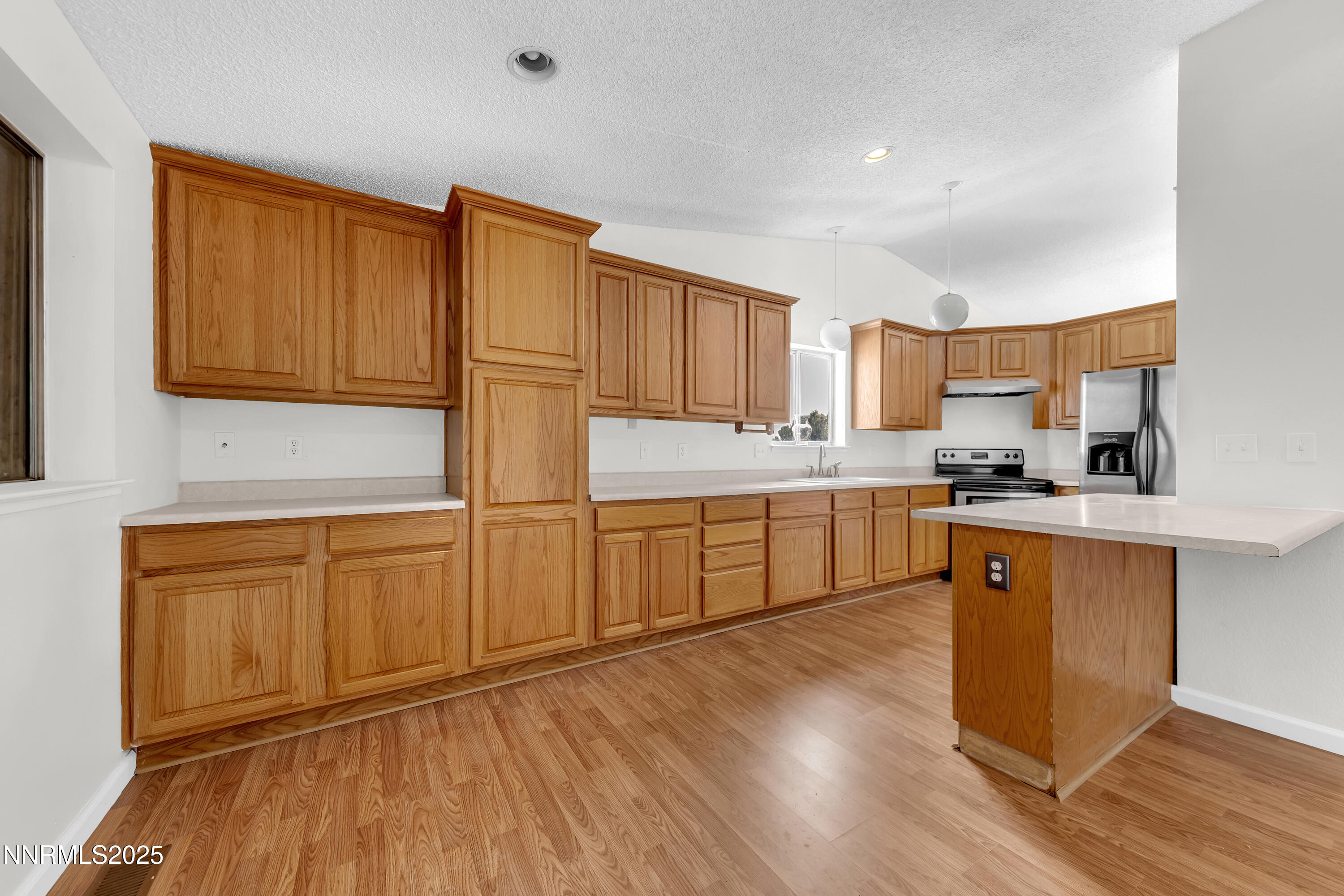 8581 Corrigan Way Reno, NV 89506 - Photo 12 of 40 a kitchen with stainless steel appliances granite countertop a sink a stove a refrigerator cabinets and wooden floor
