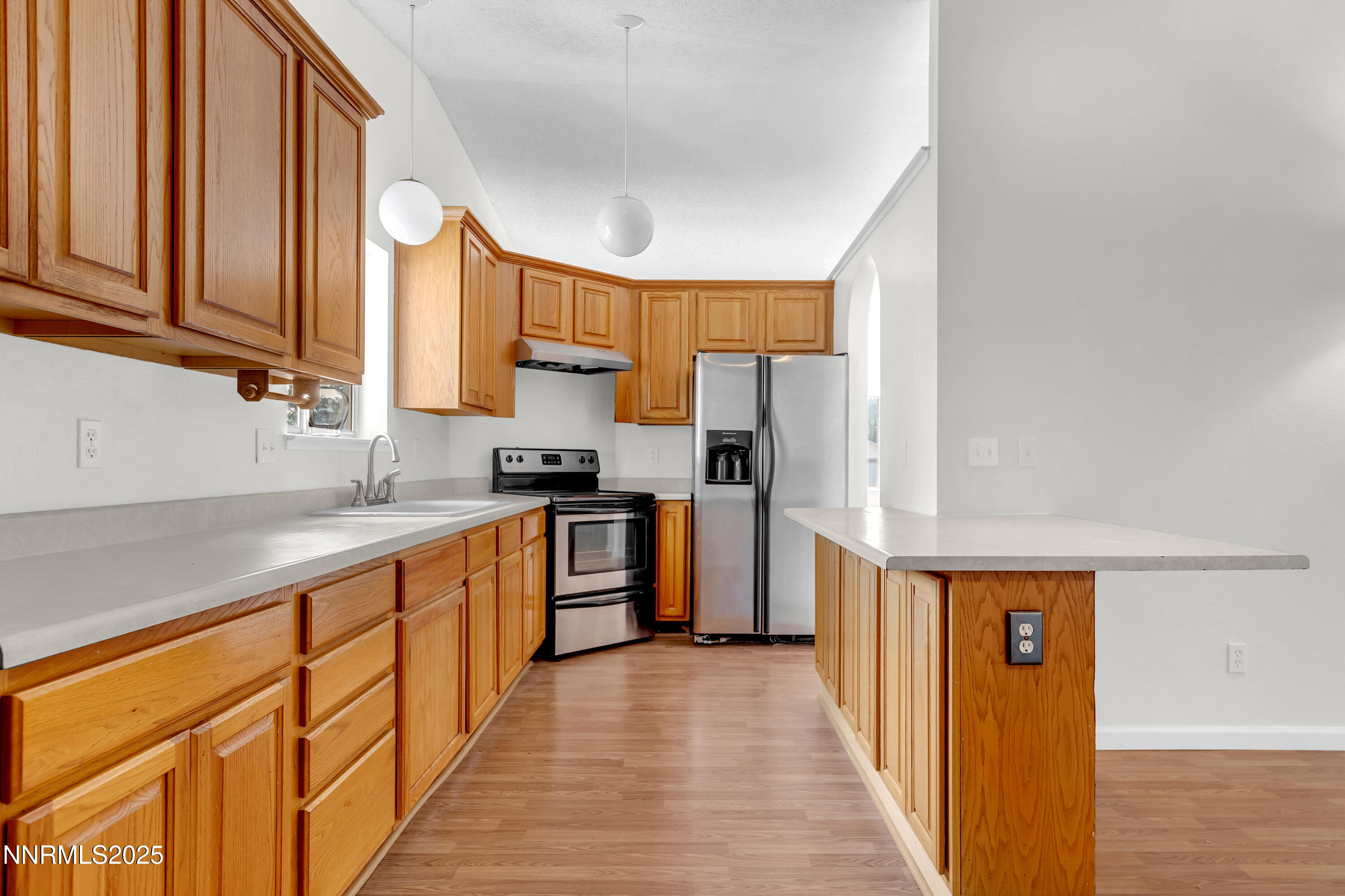 8581 Corrigan Way Reno, NV 89506 - Photo 14 of 40 a kitchen with stainless steel appliances a refrigerator sink and cabinets