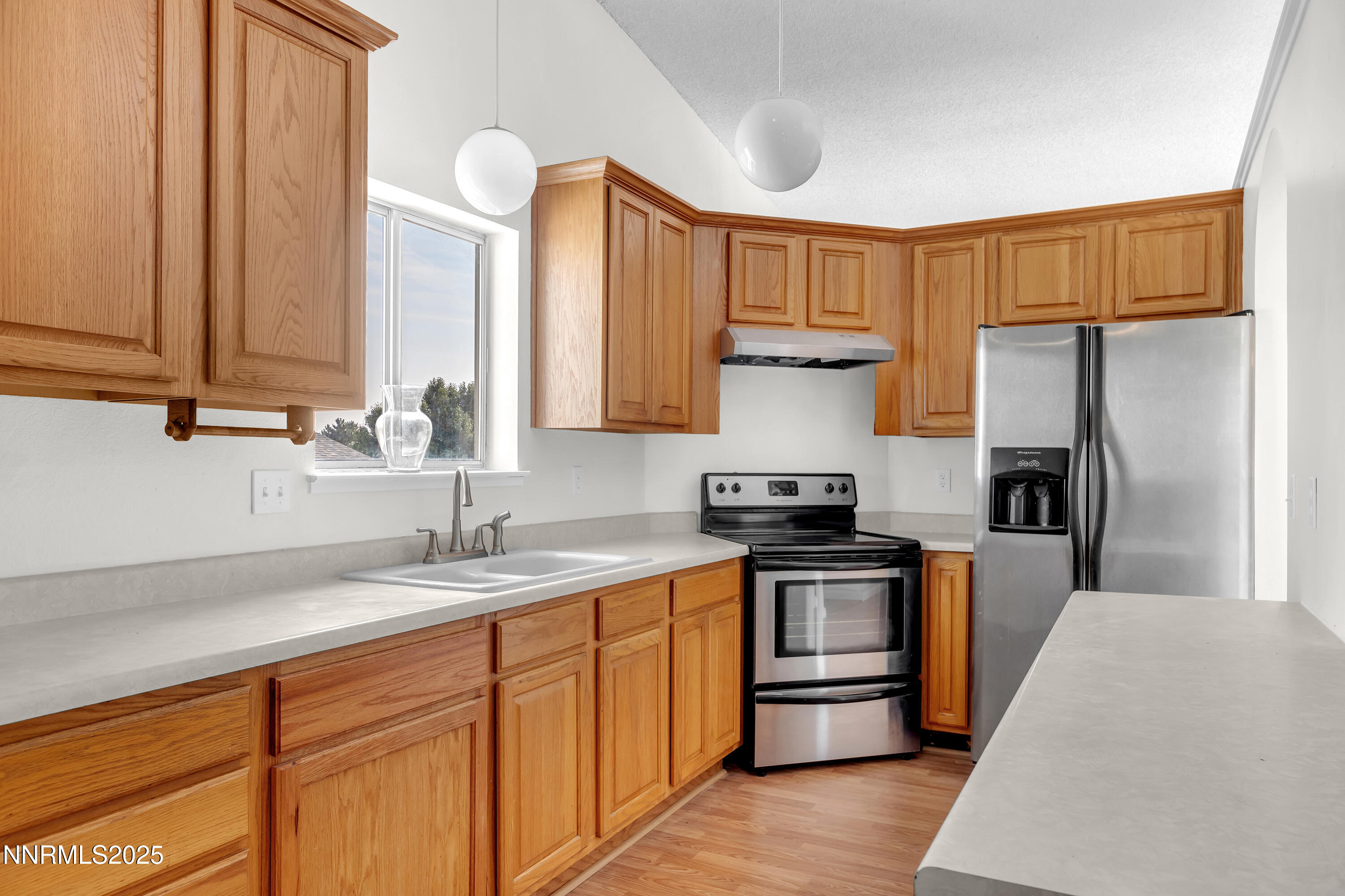 8581 Corrigan Way Reno, NV 89506 - Photo 15 of 40 a kitchen with stainless steel appliances a sink cabinets and a counter top space
