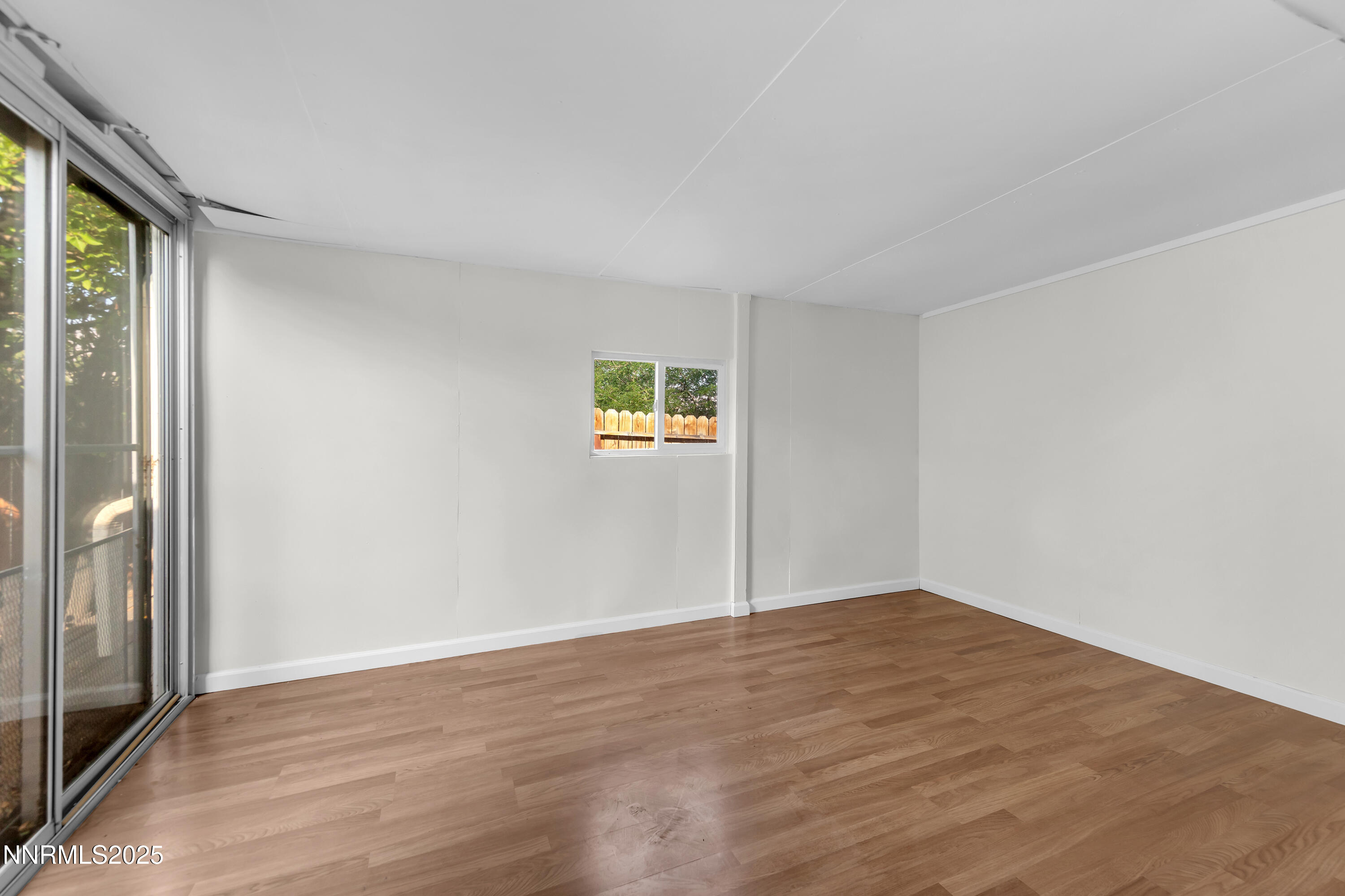 8581 Corrigan Way Reno, NV 89506 - Photo 17 of 40 a view of an empty room with wooden floor and a window