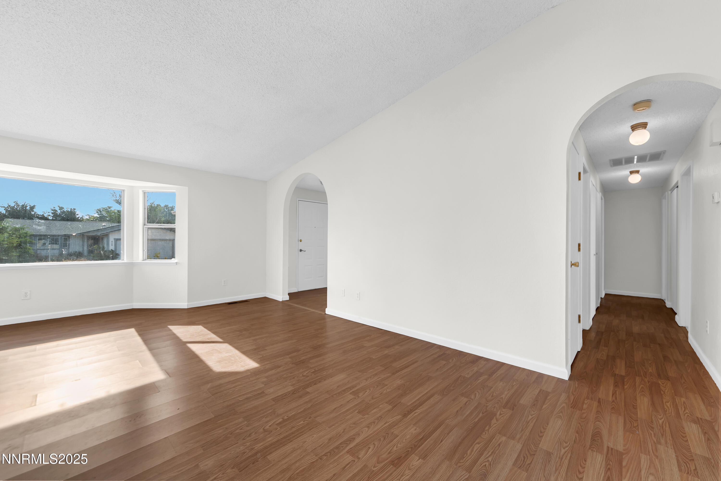 8581 Corrigan Way Reno, NV 89506 - Photo 9 of 40 a view of an empty room with wooden floor and a window