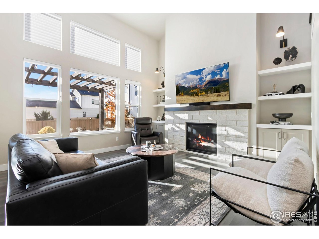 6709 Stone Point Drive Timnath, CO 80547 - Photo 13 of 41 a living room with furniture a flat screen tv and a fireplace