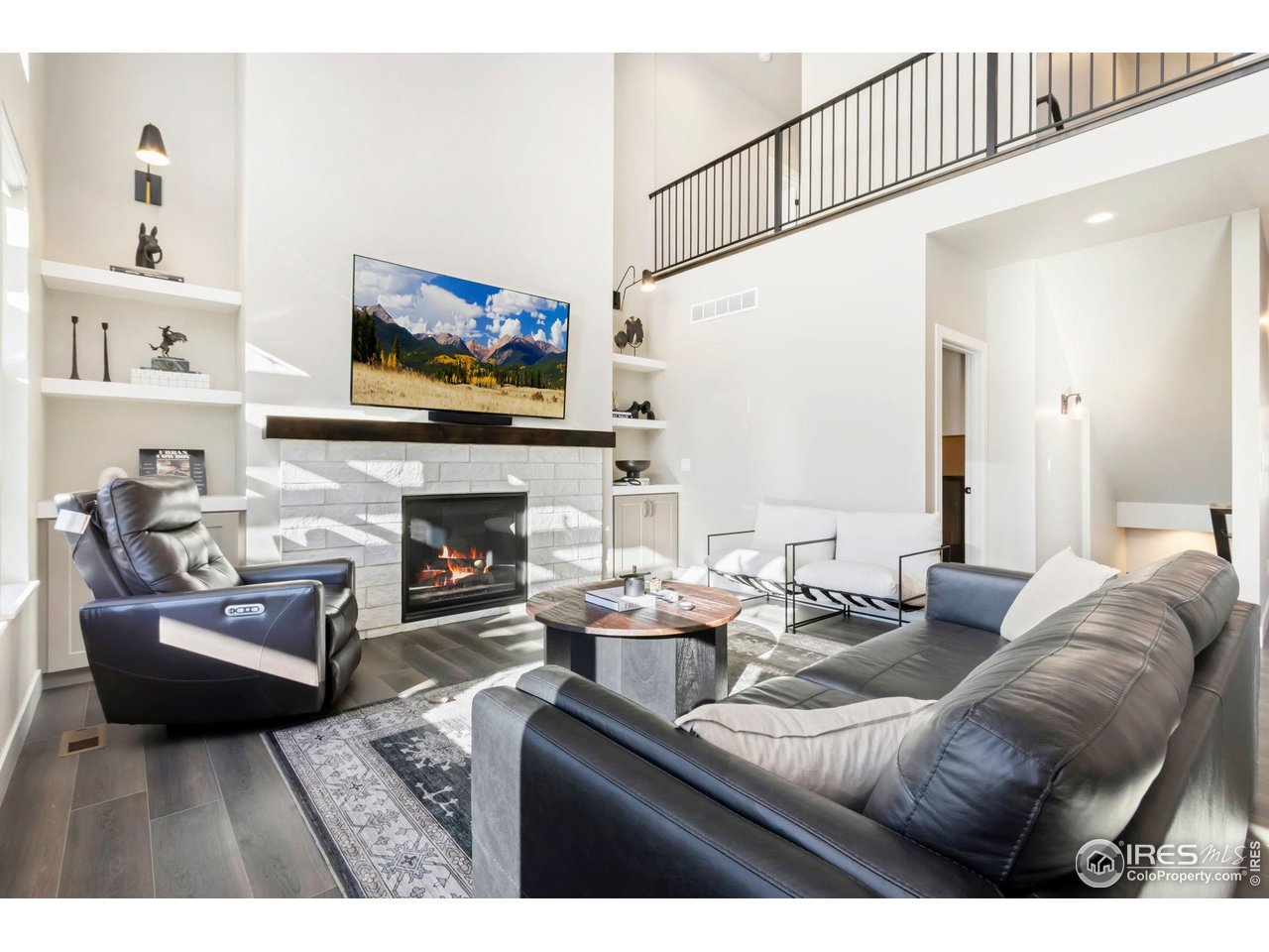 6709 Stone Point Drive Timnath, CO 80547 - Photo 15 of 41 a living room with furniture a flat screen tv and a fireplace