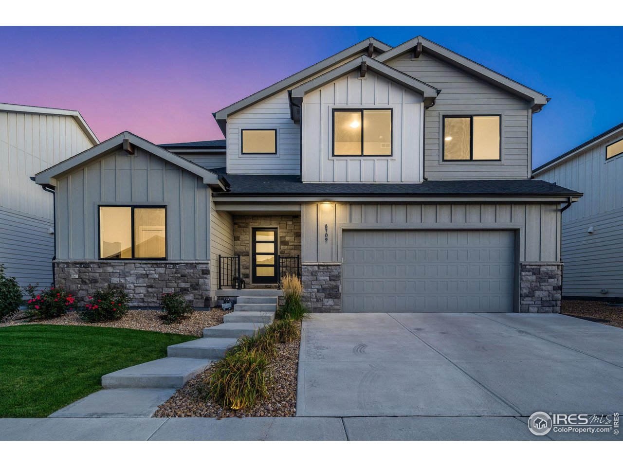 6709 Stone Point Drive Timnath, CO 80547 - Photo 2 of 41 a front view of a house with a yard and garage