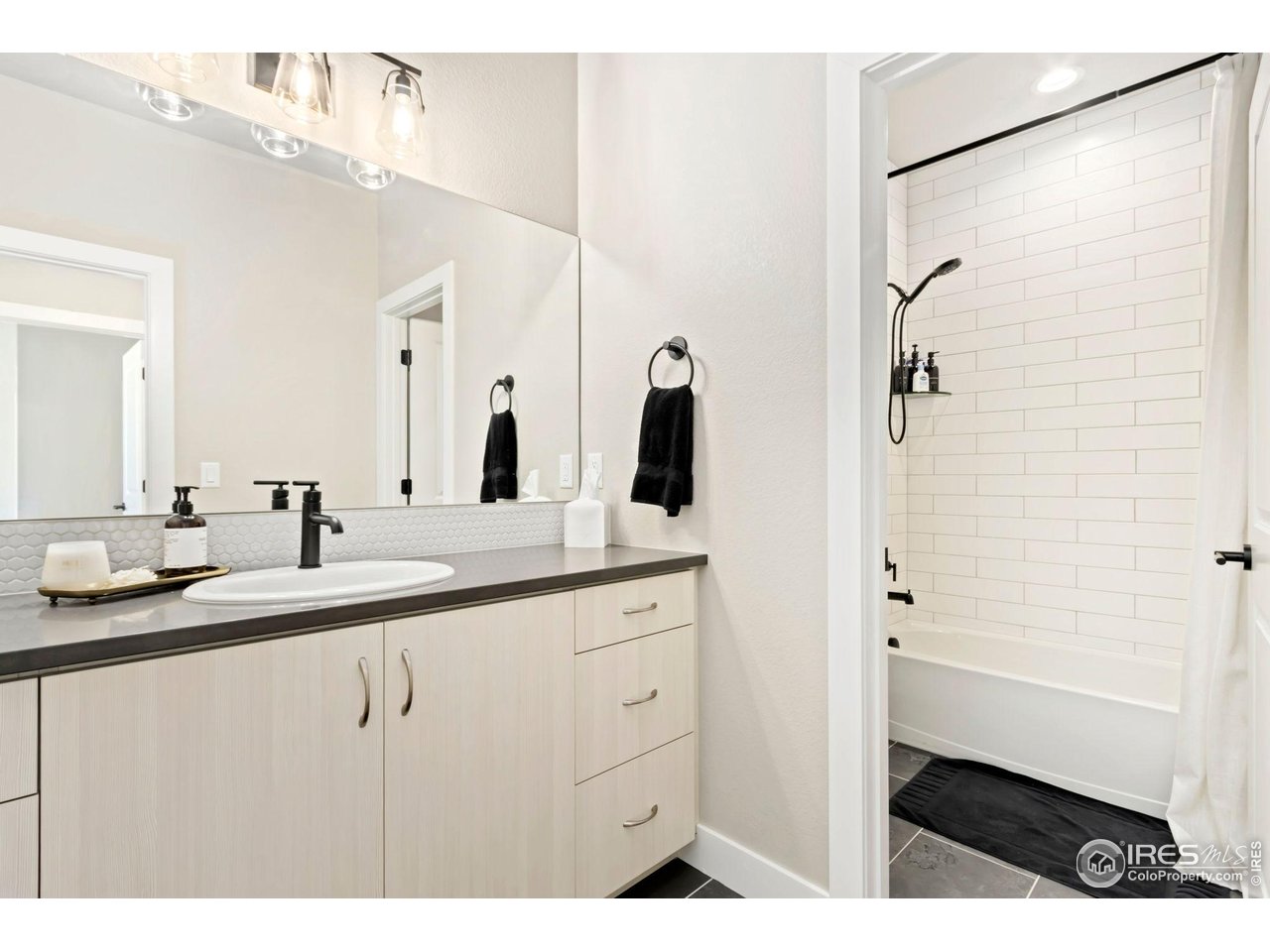 6709 Stone Point Drive Timnath, CO 80547 - Photo 30 of 41 a bathroom with a double vanity sink a mirror and a shower