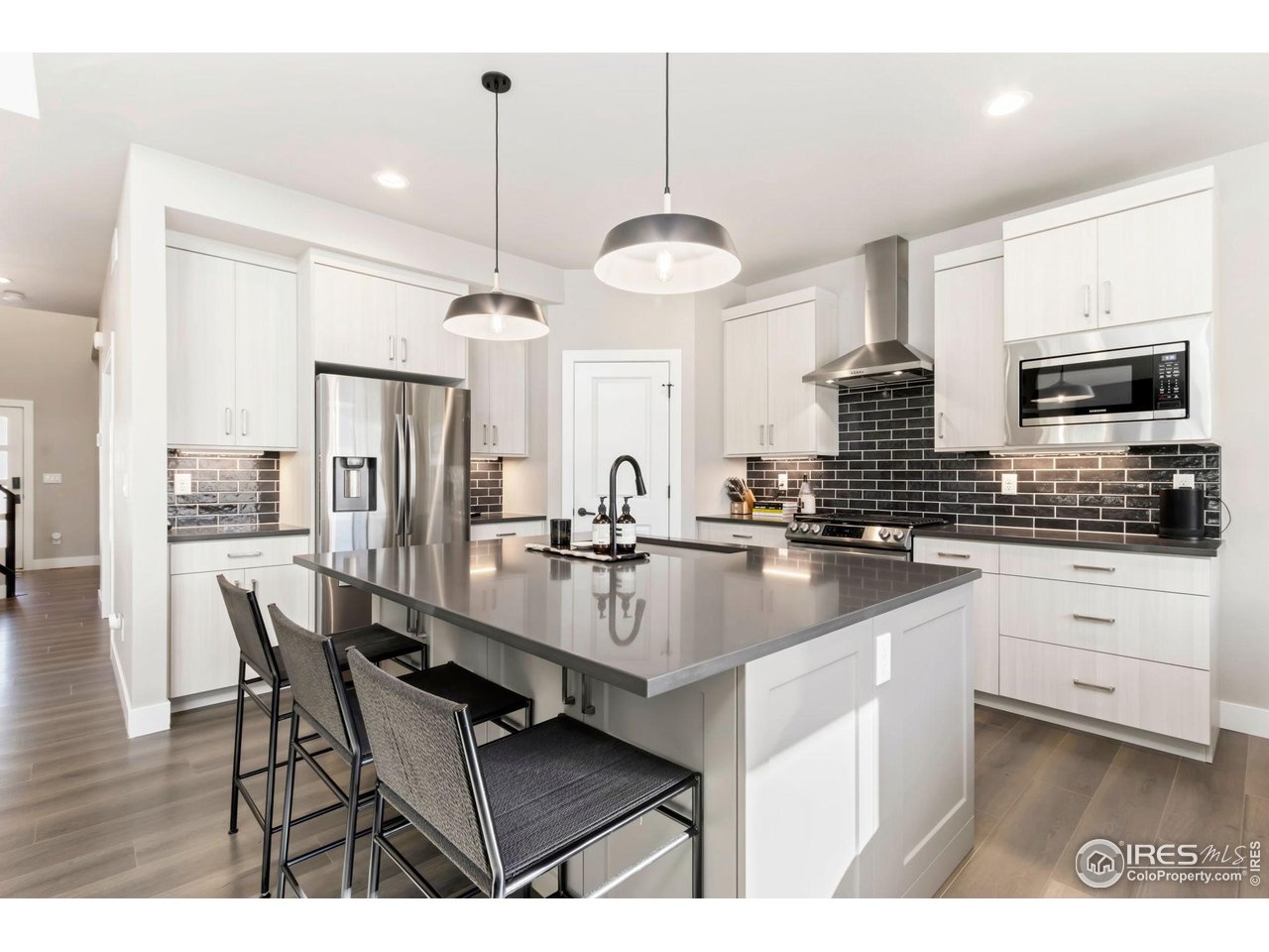 6709 Stone Point Drive Timnath, CO 80547 - Photo 10 of 41 a kitchen with stainless steel appliances kitchen island granite countertop a sink and microwave