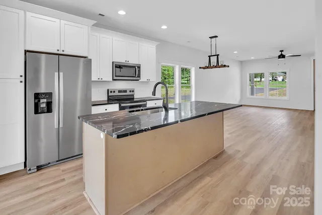 a kitchen with stainless steel appliances a refrigerator and a stove top oven