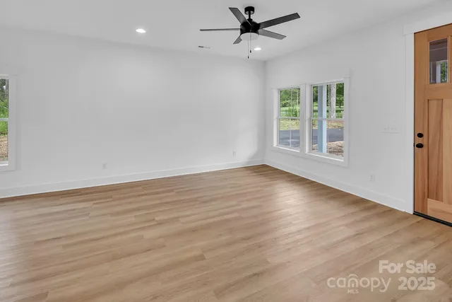 a view of a kitchen with wooden floor and a window