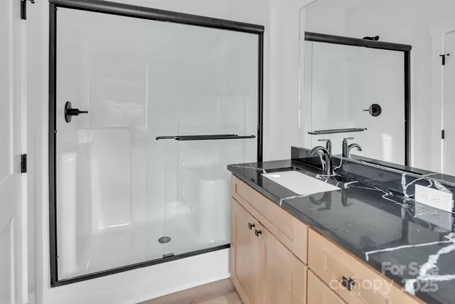 a bathroom with a granite countertop sink toilet and mirror