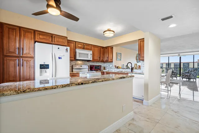 a kitchen with stainless steel appliances granite countertop a refrigerator sink and stove