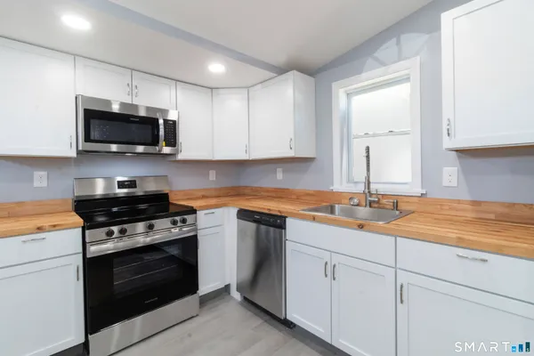 a kitchen with cabinets stainless steel appliances a sink and a stove