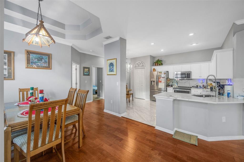 20804 Eustis Road Land O Lakes, FL 34637 - Photo 12 of 65 a dining room with stainless steel appliances kitchen island granite countertop a dining table chairs and a refrigerator