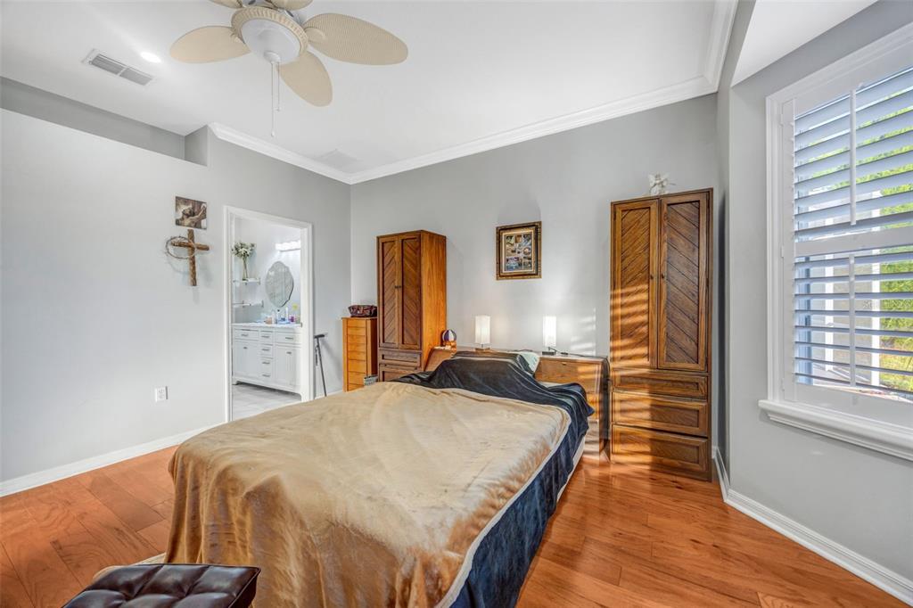 20804 Eustis Road Land O Lakes, FL 34637 - Photo 19 of 65 a bed room with a bed and a chandelier