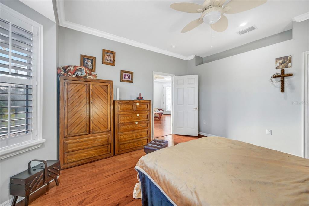 20804 Eustis Road Land O Lakes, FL 34637 - Photo 21 of 65 a bedroom with a bed and wooden floor