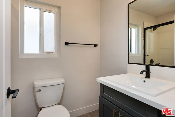 a bathroom with a toilet a sink and mirror