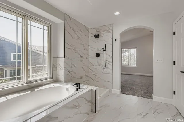 a spacious bathroom with a granite countertop tub shower and sink