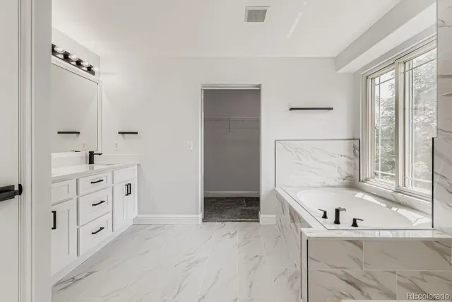 a bathroom with a bathtub sink and mirror