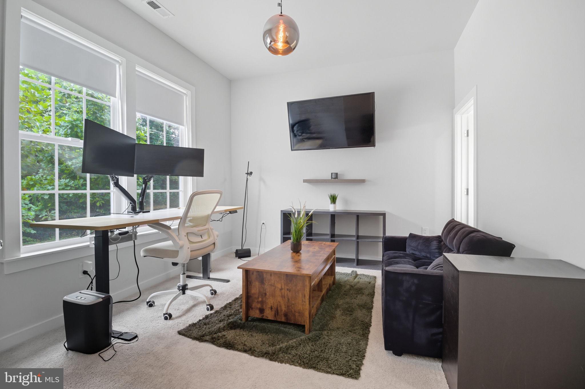 18518 Old Triangle Road Triangle, VA 22172 - Photo 34 of 39 a living room with furniture a flat screen tv and a floor to ceiling window