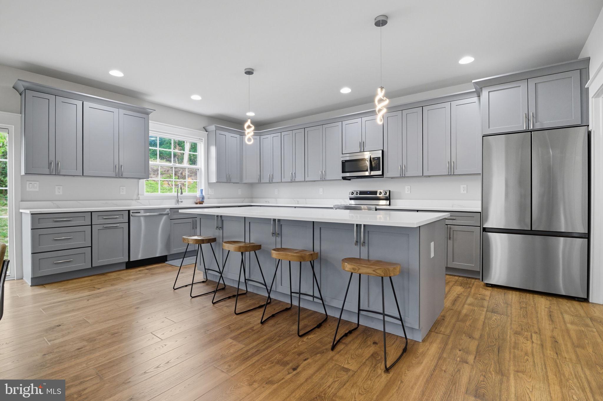 18518 Old Triangle Road Triangle, VA 22172 - Photo 5 of 39 a kitchen with stainless steel appliances granite countertop a refrigerator a sink a stove a microwave and white cabinets with wooden floor