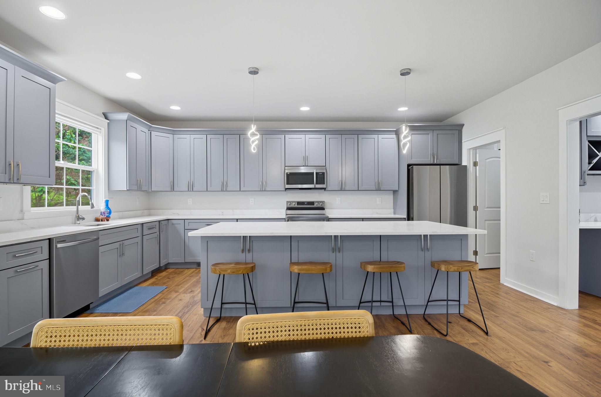 18518 Old Triangle Road Triangle, VA 22172 - Photo 6 of 39 a kitchen with a refrigerator a sink dishwasher a stove and a cabinets with wooden floor