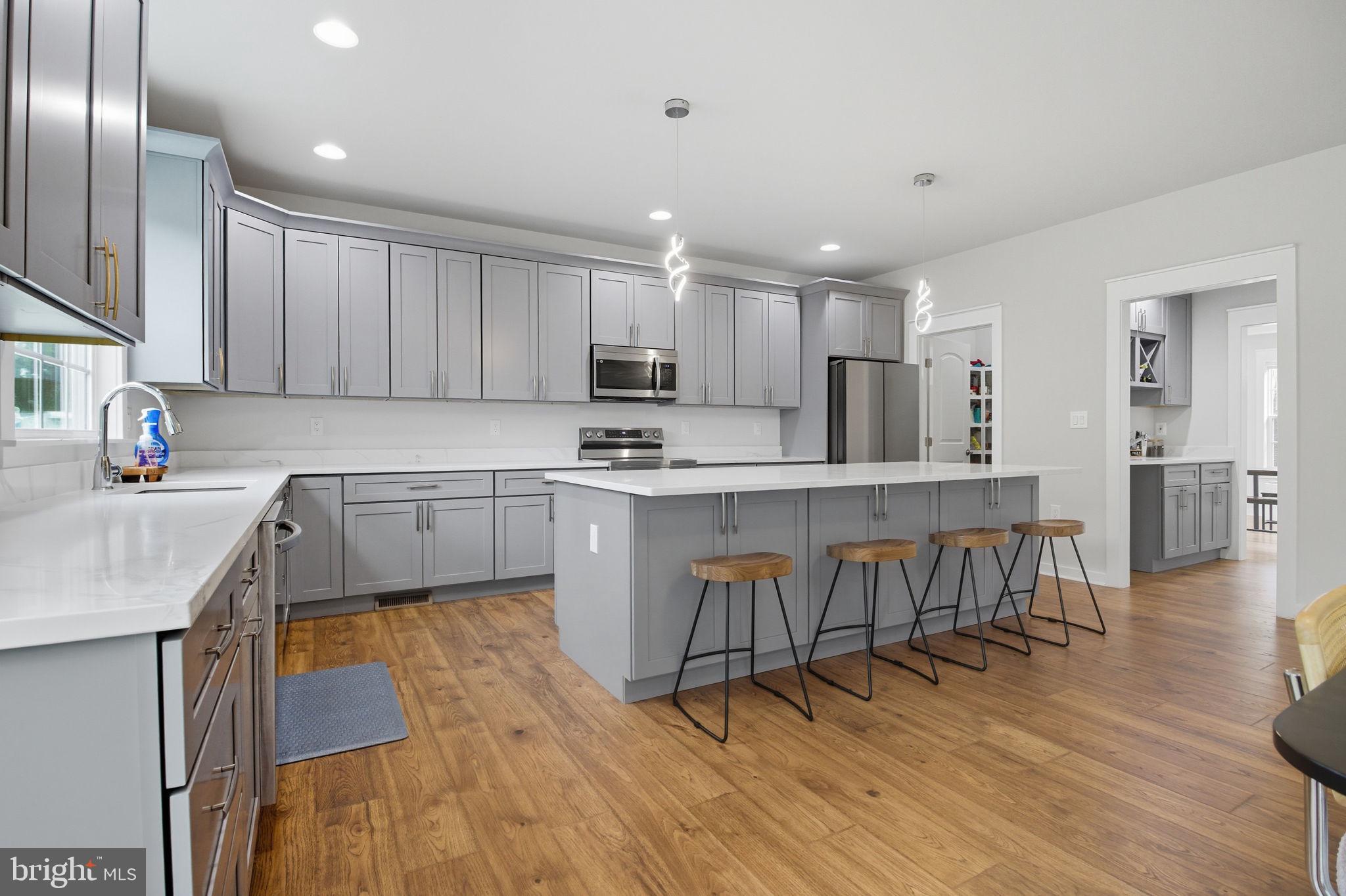18518 Old Triangle Road Triangle, VA 22172 - Photo 7 of 39 a kitchen with a table chairs a sink dishwasher stove and cabinets with wooden floor