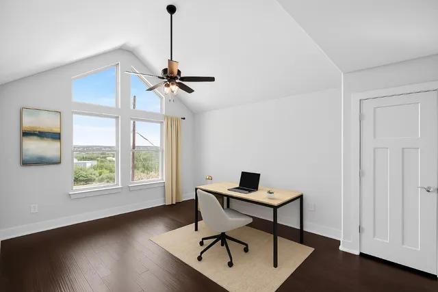 a view of a workspace with furniture and a window