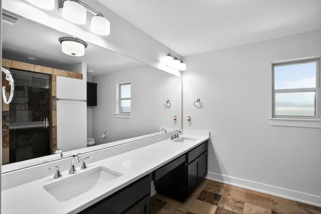 a bathroom with a sink double vanity granite and a mirror
