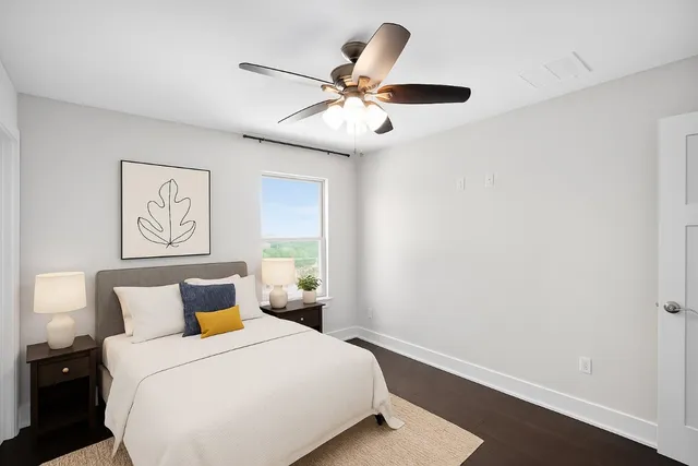 a bedroom with a large bed and a ceiling fan