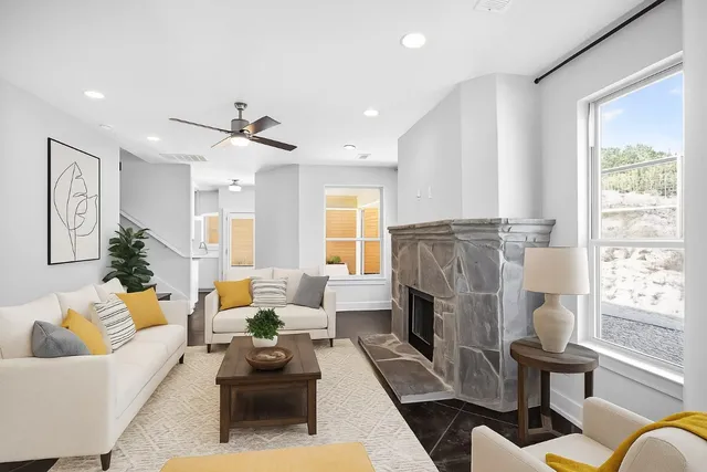 a living room with furniture fireplace and a large window