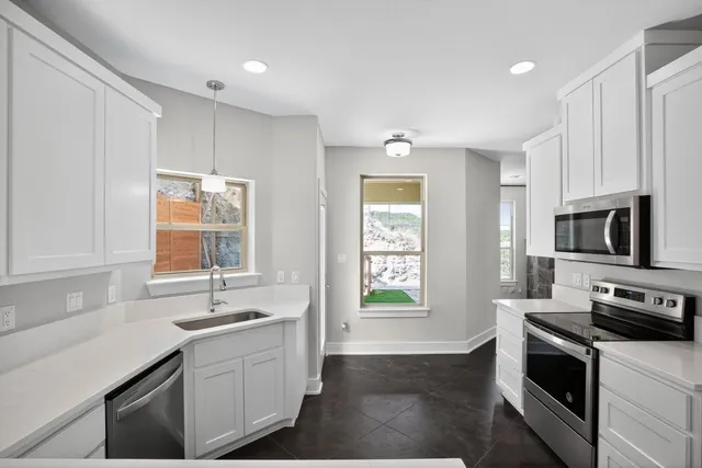 a kitchen with a sink stove and microwave