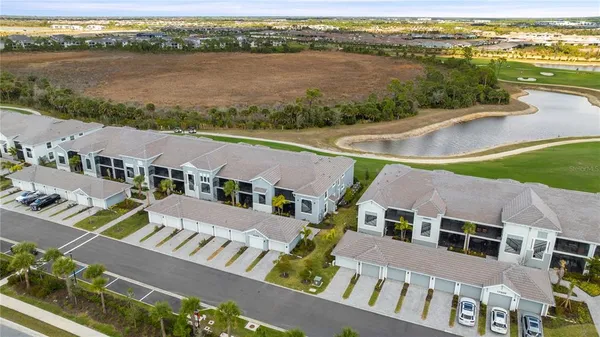 an aerial view of residential houses with outdoor space and ocean view
