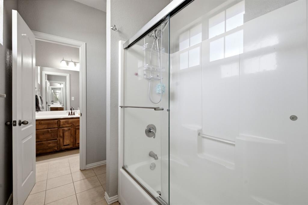 600 Aspen Street Pilot Point, TX 76258 - Photo 29 of 39 Bathtub/shower combination with sliding glass enclosure and grab bar