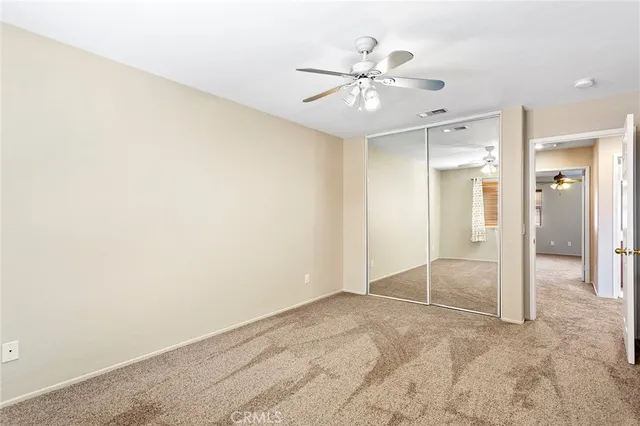 an empty room with windows and fan