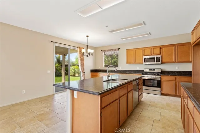 a kitchen with stainless steel appliances granite countertop a stove top oven a sink a counter space and cabinets