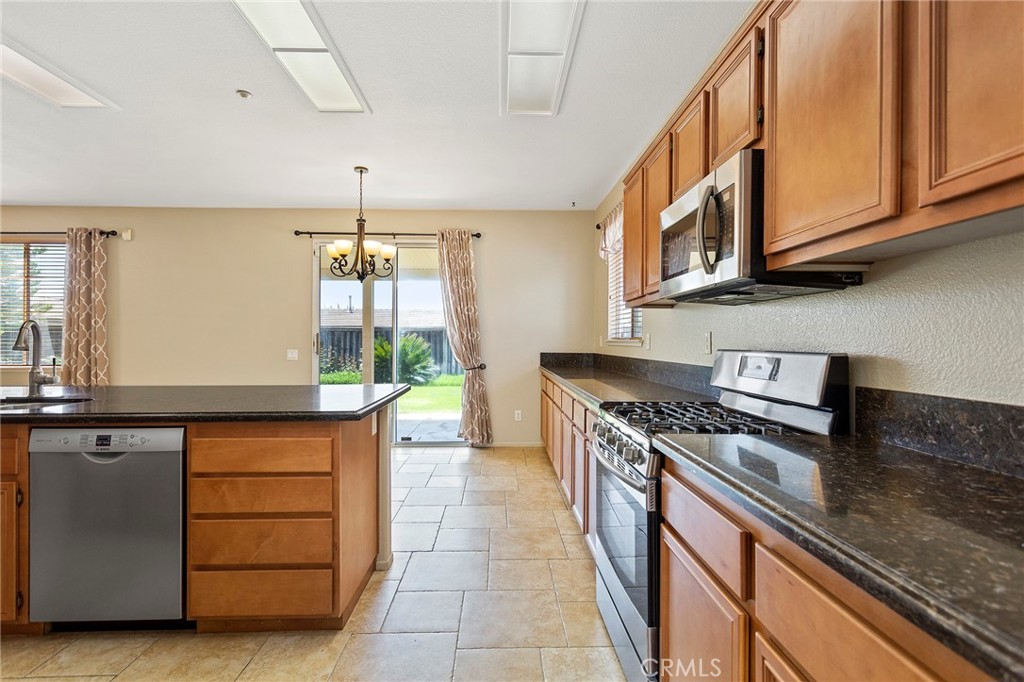 8061 Palm View Lane Riverside, CA 92508 - Photo 5 of 23 a kitchen with stainless steel appliances granite countertop a stove a sink and a microwave