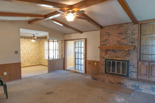 a view of an empty room with a fireplace and a window
