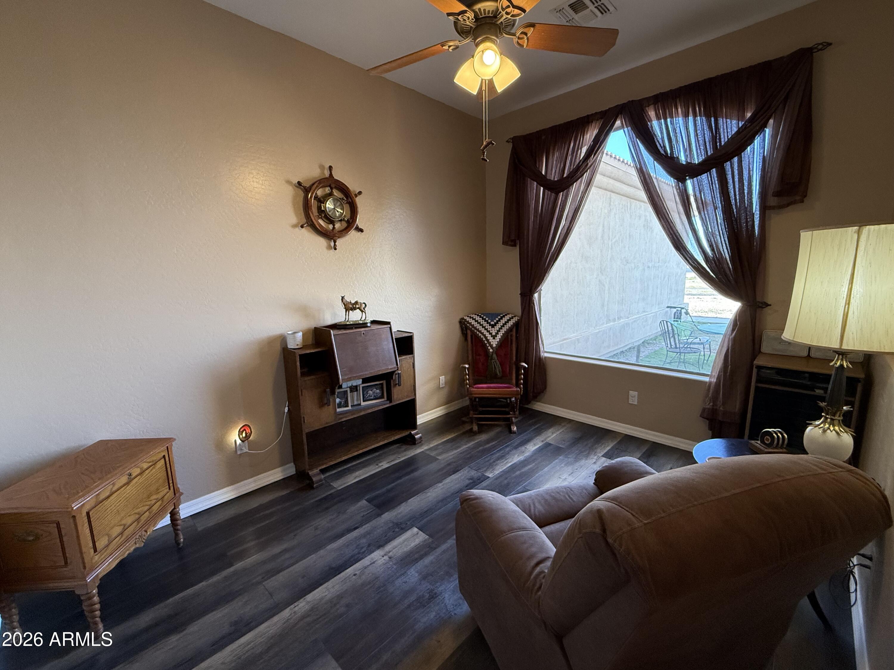 2569 West Silverdale Road San Tan Valley, AZ 85144 - Photo 9 of 61 a living room with furniture a fireplace and a flat screen tv
