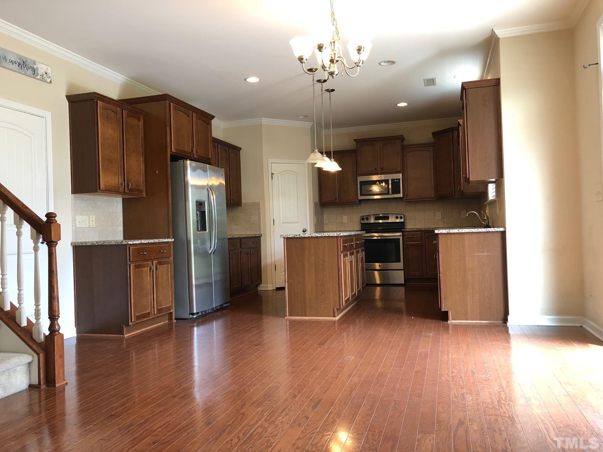 4252 Brintons Cottage Street Raleigh, NC 27616 - Photo 5 of 19 a kitchen with stainless steel appliances kitchen island granite countertop a refrigerator a stove a sink and a microwave