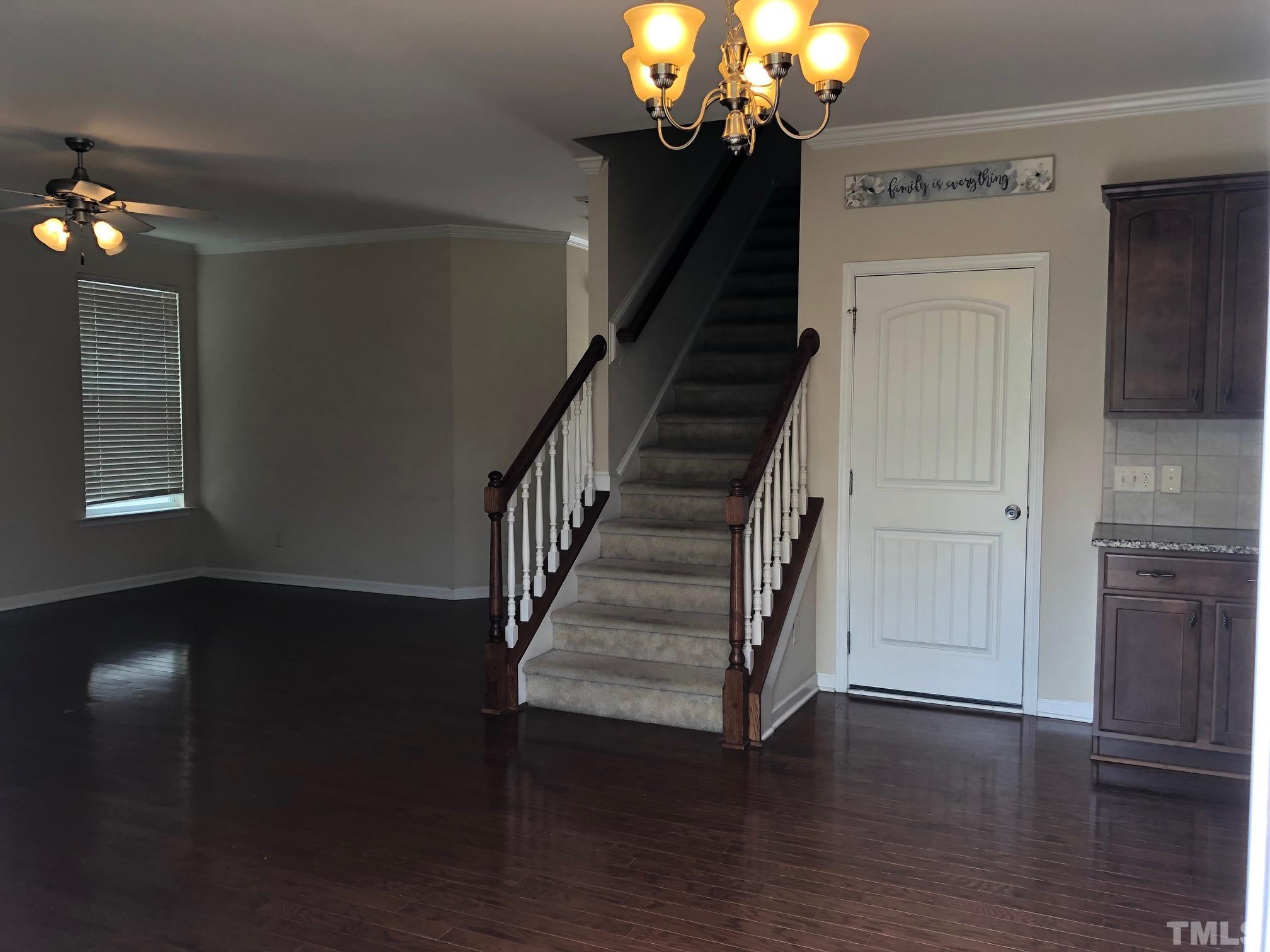 4252 Brintons Cottage Street Raleigh, NC 27616 - Photo 8 of 19 a view of a livingroom with wooden floor staircase and a chandelier