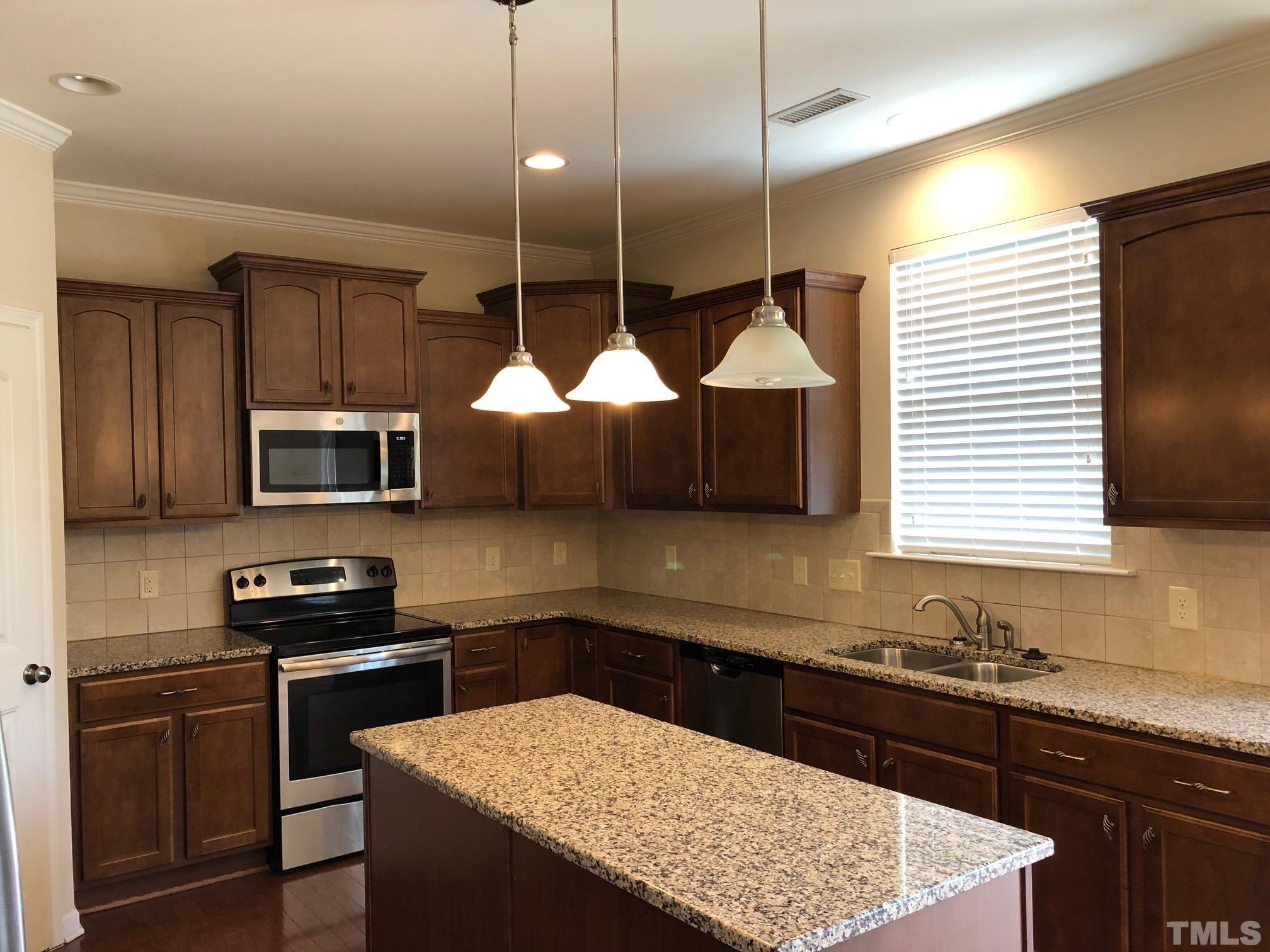 4252 Brintons Cottage Street Raleigh, NC 27616 - Photo 9 of 19 a kitchen with stainless steel appliances granite countertop a sink a stove and a refrigerator