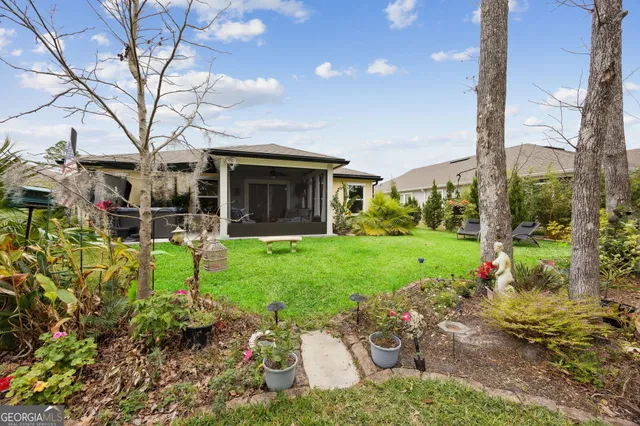a view of a chair and table in backyard of the house