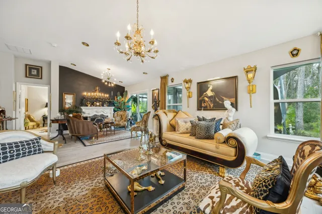 a living room with furniture a chandelier and a flat screen tv
