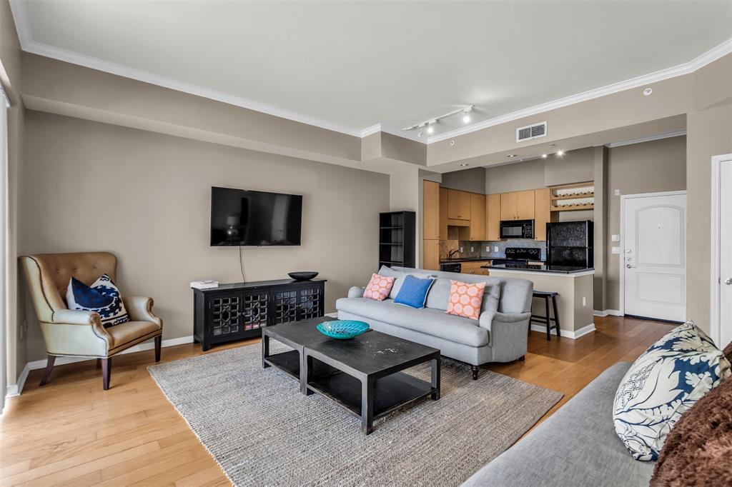 3225 Turtle Creek Boulevard, Unit 10 Dallas, TX 75219 - Photo 19 of 38 Living area featuring light wood-style floors, ornamental molding, and track lighting