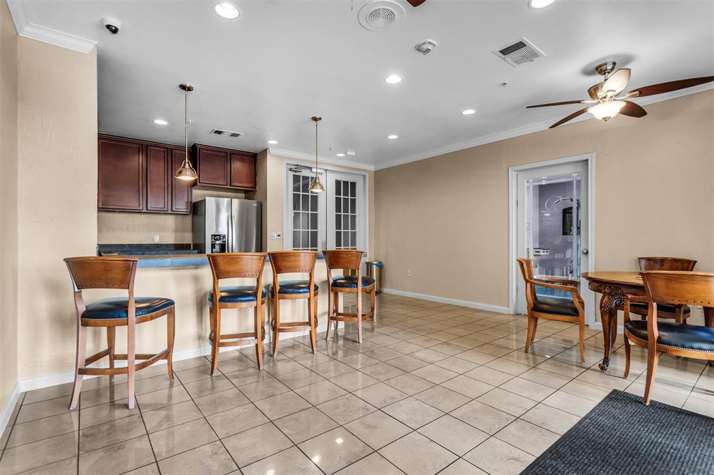 3225 Turtle Creek Boulevard, Unit 10 Dallas, TX 75219 - Photo 34 of 38 Kitchen featuring a kitchen bar, ornamental molding, a peninsula, decorative light fixtures, and recessed lighting