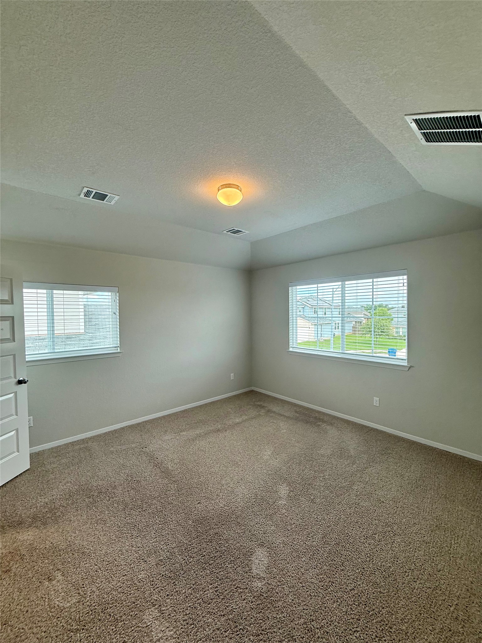 212 Lake Placid Run Elgin, TX 78621 - Photo 13 of 27 A quiet bedroom featuring plush carpeting and generous natural light from broad windows.
