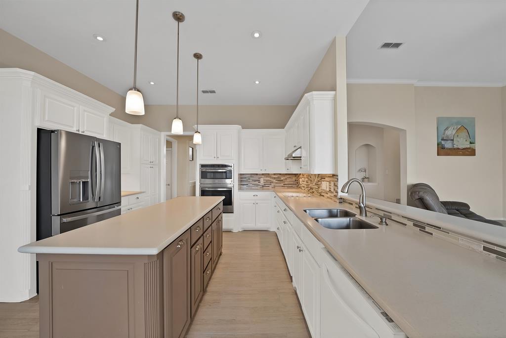 11692 Foutch Road Pilot Point, TX 76258 - Photo 11 of 40 a kitchen with a sink a counter top space a stove and a wooden floor